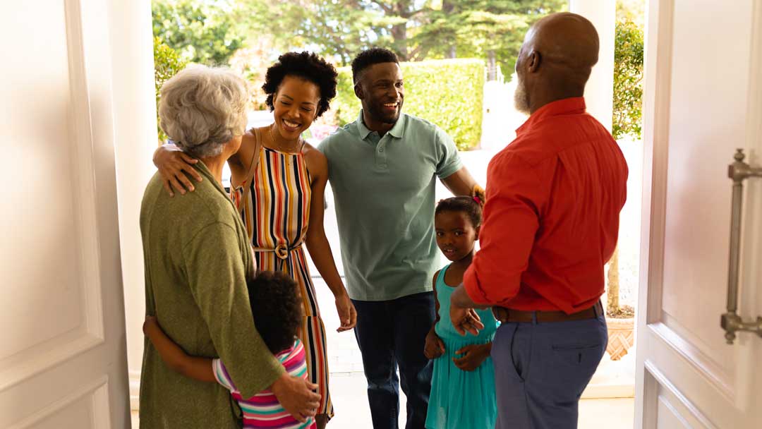 African American senior couple welcoming their family